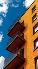 An orange brick building with balconies against a blue sky