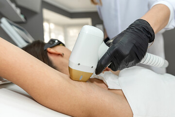 A woman is currently undergoing a laser hair removal treatment for her underarm area, hairfree skin