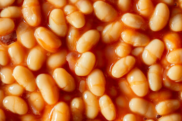 Baked beans in a tomato sauce background backdrop. Traditional British food concept