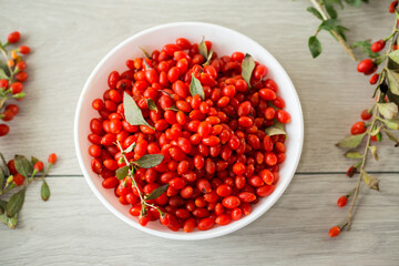 fresh ripe red goji berries in a bowl on a wooden table