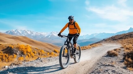 Fototapeta premium Mountain Biker Riding Through Scenic Landscape with Snow-Capped Peaks and Autumn Foliage