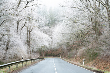 Icy snow covered road, ground frost in winter, moisture fog in morning, low visibility, slippery...