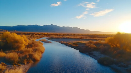 Fototapeta premium Autumn sunset over river, mountains, and golden trees. Peaceful landscape for travel brochures, calendars, or nature documentaries.