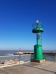 Lighthouse on the pier in a sunny day with a blue sky