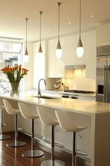 Modern kitchen with sleek design, bar stools, and fresh flowers.