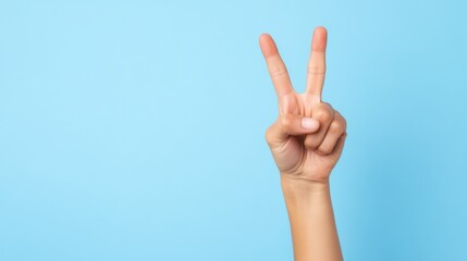 Fototapeta premium Hand with Peace Sign Gesture against Light Blue Background for Positive Messaging and Social Communication