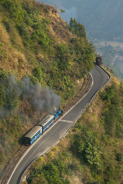 The toy train of Darjeeling heading towards Darjeeling crossing the beautiful landscape view. 