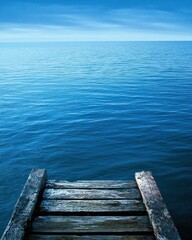 Fototapeta premium Tranquil Wooden Dock Overlooking Calm Blue Ocean Under Clear Sky