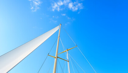 Fototapeta premium Sails and mast in the blue sky. isolated with white highlights