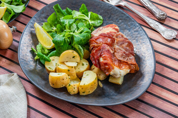 Prosciutto wrapped chicken with herby potatoes and green lettuce