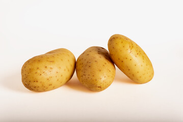 Three raw potatoes on a white background. Solanum tuberosum.