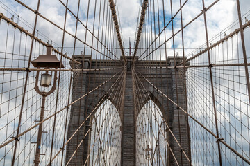 Obraz premium A view looking up at the first support tower on the Brooklyn Bridge leaving Manhattan, New York, in the fall 