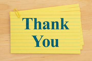 Yellow index cards with thank you text and paperclip