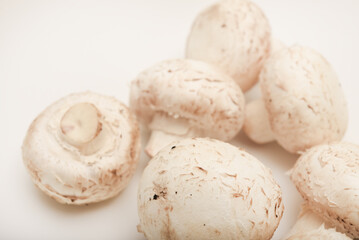 Fresh champignons on a white plate. Mushrooms on a white background.