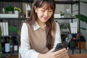 Fototapeta premium Student asian woman lying use smart phone in dorm room college mobile addict spending time checking news technology e-commerce.