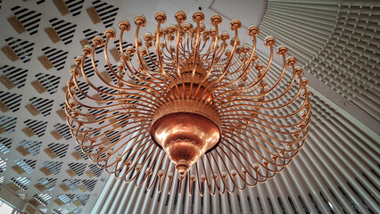 A magnificent, multi-tiered chandelier with radiating arms hangs beneath a geometrically patterned...