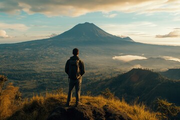 A man standing on top of the mountain, overlooking distant mountains and sky at sunrise with copy space text. Horizontal shot, wide-angle lens, natural lighting, best quality, realistic photo
