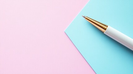 White pen with gold accents on pink and blue background.