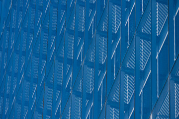 Looking up a glass facade of an office building.