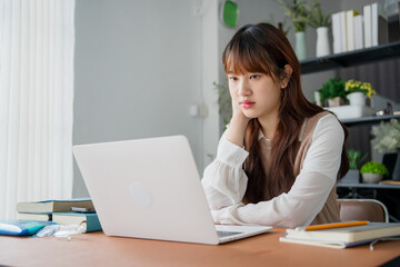 Asian woman watching video from online classroom