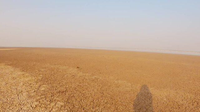 Drought land of Kutch desert. Natural pattern of desert land. Cracked, dry soil due to lack of water and hot weather in Little Rann of Kutch, Gujarat. Desert landscape. Travel and holidays concept
