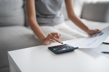 Asian Woman Pressing calculator for. financial planner remotely Personal finance at home.