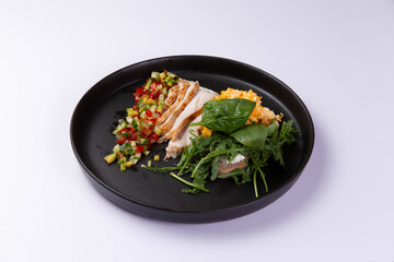 Fried egg with mash and grilled vegetables in a plate on a light background.