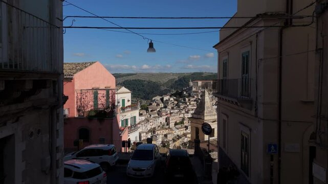 following car on Corso Italia towards view of Ragusa Ibla in Sicily