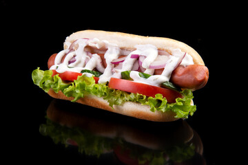 Appetizing hot dog on a dark background.