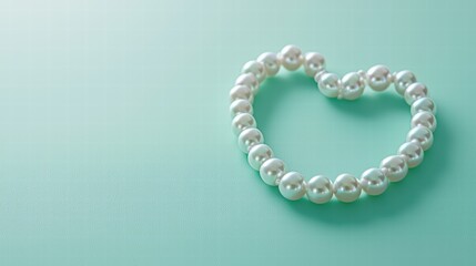 Heartshaped pearl necklace on soft pastel green background