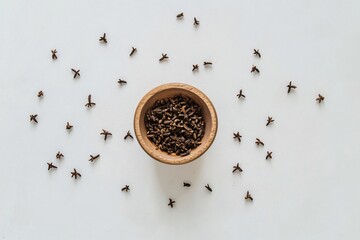 Close-Up View of Whole Cloves in Wooden Bowl Surrounded by Spices
