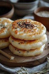Fluffy and Delicious Homemade Flatbreads with Black Sesame Seeds Served on a Wooden Plate Surrounded by Bowls of Ingredients in a Rustic Kitchen Setting