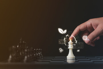 hands moving chess pieces, showcasing business strategy and planning for 2025 with a focus on carbon footprint reduction, energy consumption, and sustainable commercial resources