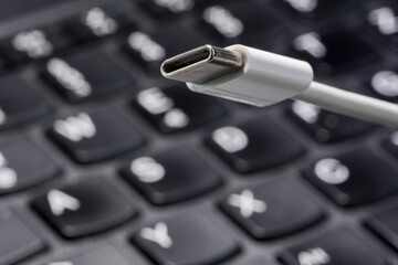 Concept photo of USB-C cable with laptop keyboard