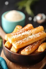 Crispy Golden Breadsticks Topped with Grated Cheese Placed in a Wooden Bowl Surrounded by Fresh Ingredients on a Dark Table