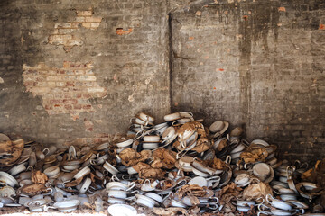 Auf dem Gelände einer ehemaligen Schesternschule liegen viele Bettpfannen in einer Ecke.