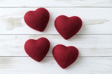 Obraz premium Red hearts on a white wooden background with copy space for a Valentine's Day celebration, a flat lay composition, top view. Love concept. Flat lay composition of red heart-shaped candles and fabric