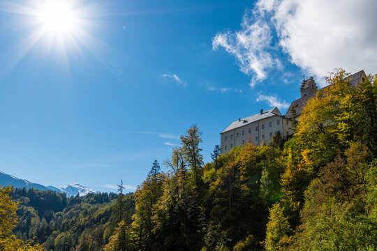 St. Georgenberg Abbey in Tyrol, Austria, perched on a rocky cliff surrounded by colorful autumn forest
