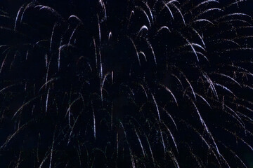A dazzling display of golden fireworks streaking across the night sky, accented by vibrant red...