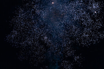 A dazzling display of golden fireworks streaking across the night sky, accented by vibrant red...