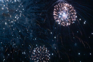 A dazzling display of golden fireworks streaking across the night sky, accented by vibrant red...
