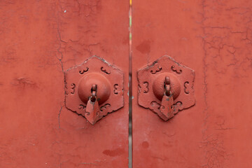 Red wooden door and cymbals of the Forbidden City in Beijing, China