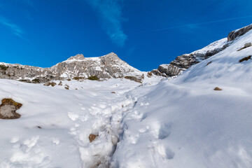 Obraz premium Winter Landscape in the Rofan Alps with Footprints in Deep Snow and Rocky Peaks