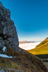 Scenic Alpine Landscape in the Rofan Range with Rugged Cliffs, Green Slopes, and Distant Peaks
