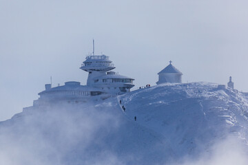 Winter view of meteorogical observatory and old chapel on the summit of Śnieżka in Karkonosze...