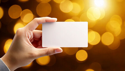 Obraz premium Prompts: Hand Holding Transparent Business Card with Golden Bokeh Background 