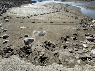 Withdrawal of dam water, drought and human footprints in the swamp. Dried lake. Water crisis and drought impact case. Withdrawal of dam water as a result of global warming. Declining water dams.
