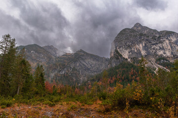Misty valley at Großer Ahornboden in the Karwendel Mountains, Austria – dramatic alpine landscape with steep cliffs, autumn meadows and low-hanging clouds