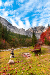 Colorful autumn landscape at Großer Ahornboden in the Karwendel Mountains, Austria – forest with fall foliage, rocky peaks and dramatic sky