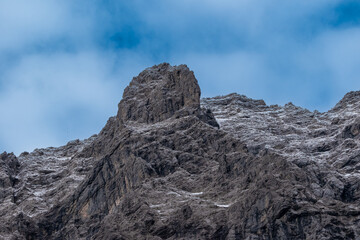 Rocky mountain peak with light snow under blue sky in the Karwendel Mountains, Austria – rugged alpine summit close-up in early winter